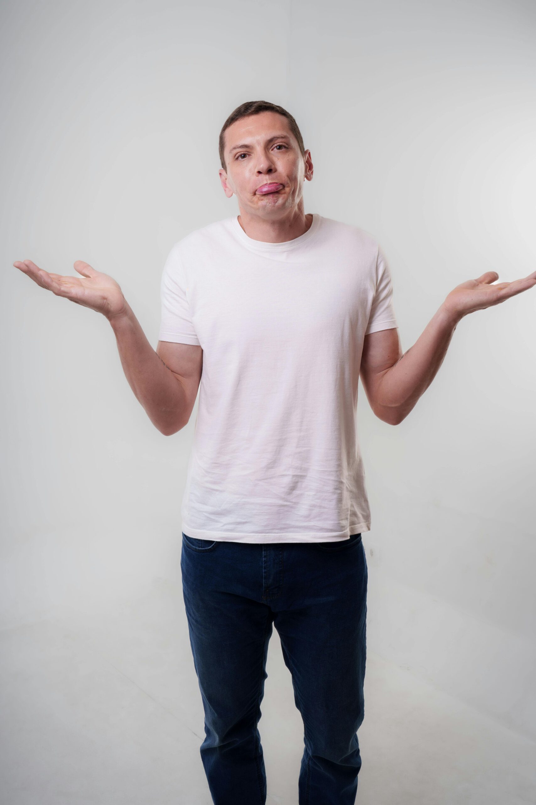 Man shrugging his shoulders with a neutral expression in studio